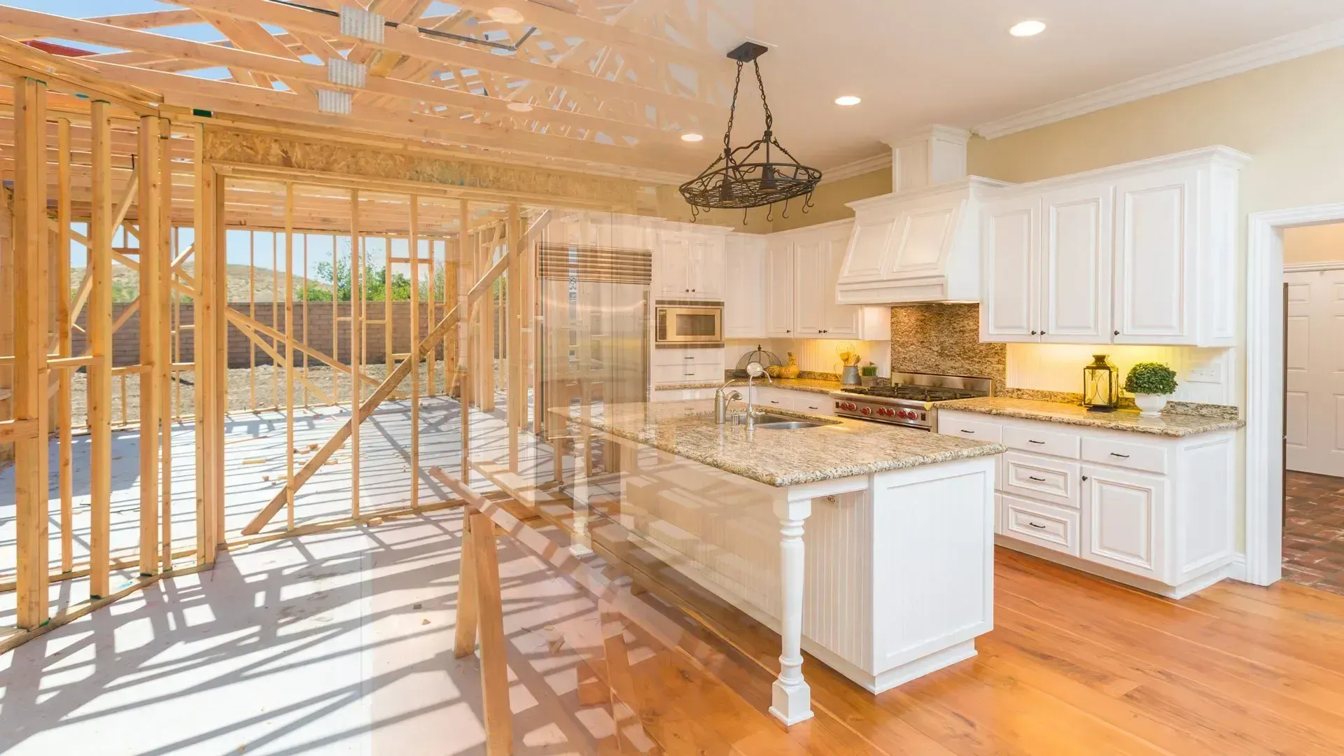 Bright kitchen with marble island, white cabinets, hardwood floors, and open framing under construction